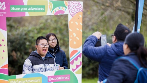 Visitors taking a picture with the Easter Adventures photo board at Morden Hall Park, London